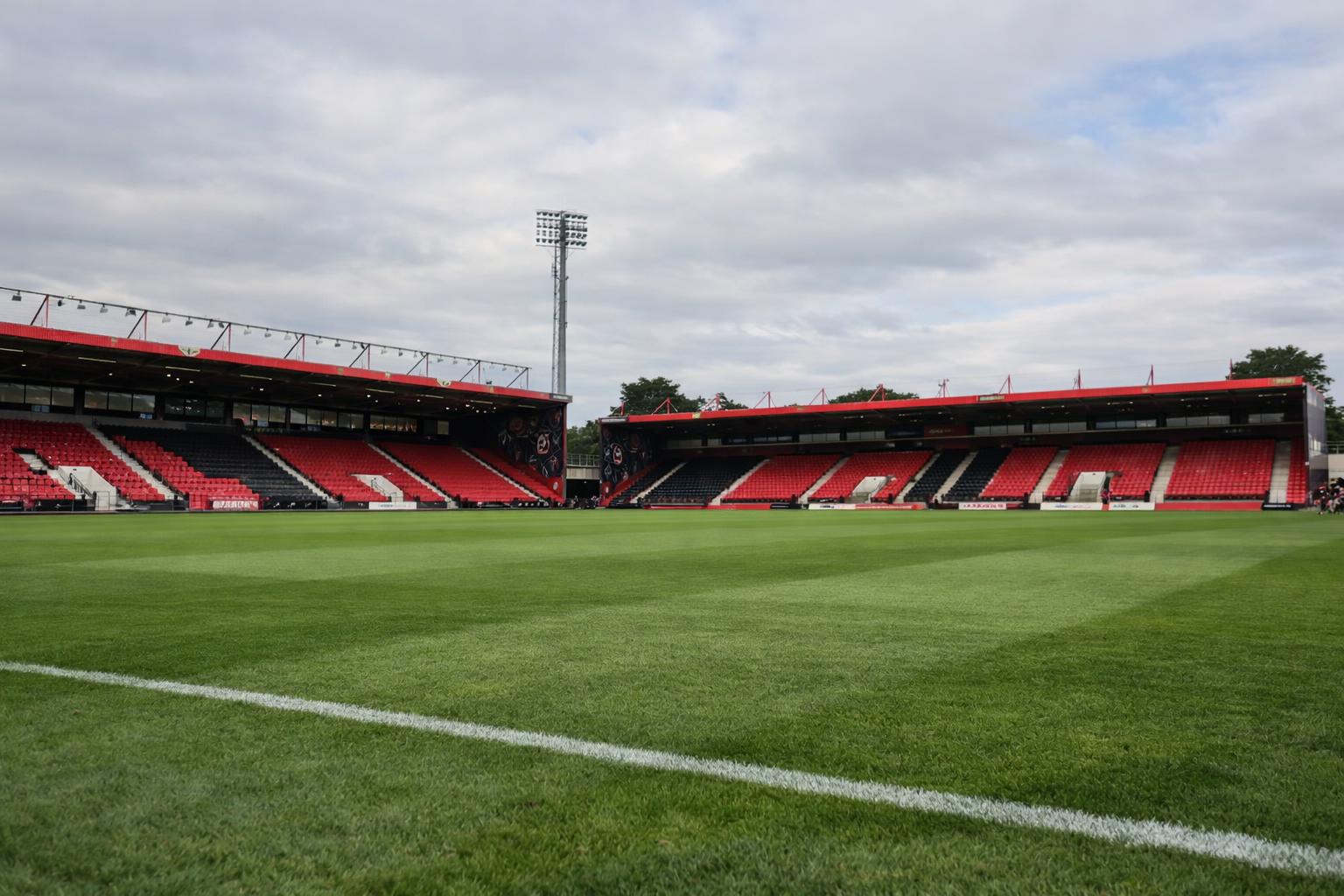 An empty pitch of Bournemouth's stadium with no writing on the stands, remove the goal from the side of the pitch