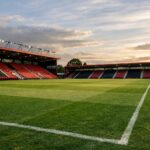 An empty pitch of Bournemouth's stadium with no writing on the stands, remove the goal from the side of the pitch